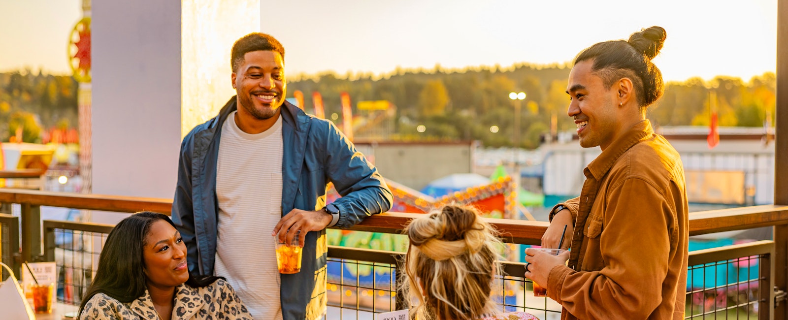 A group of four friends enjoying drinks at The 1900 Rooftop Bar during golden hour.