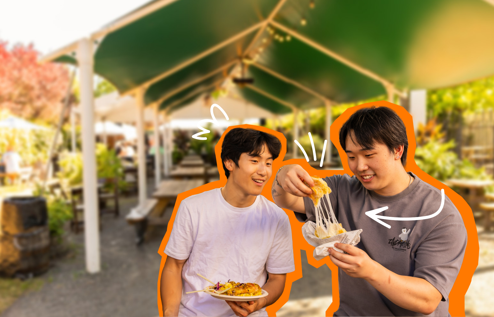 Two men holding plates of food smiling, looking at one of them stretching the cheese on his meal.
