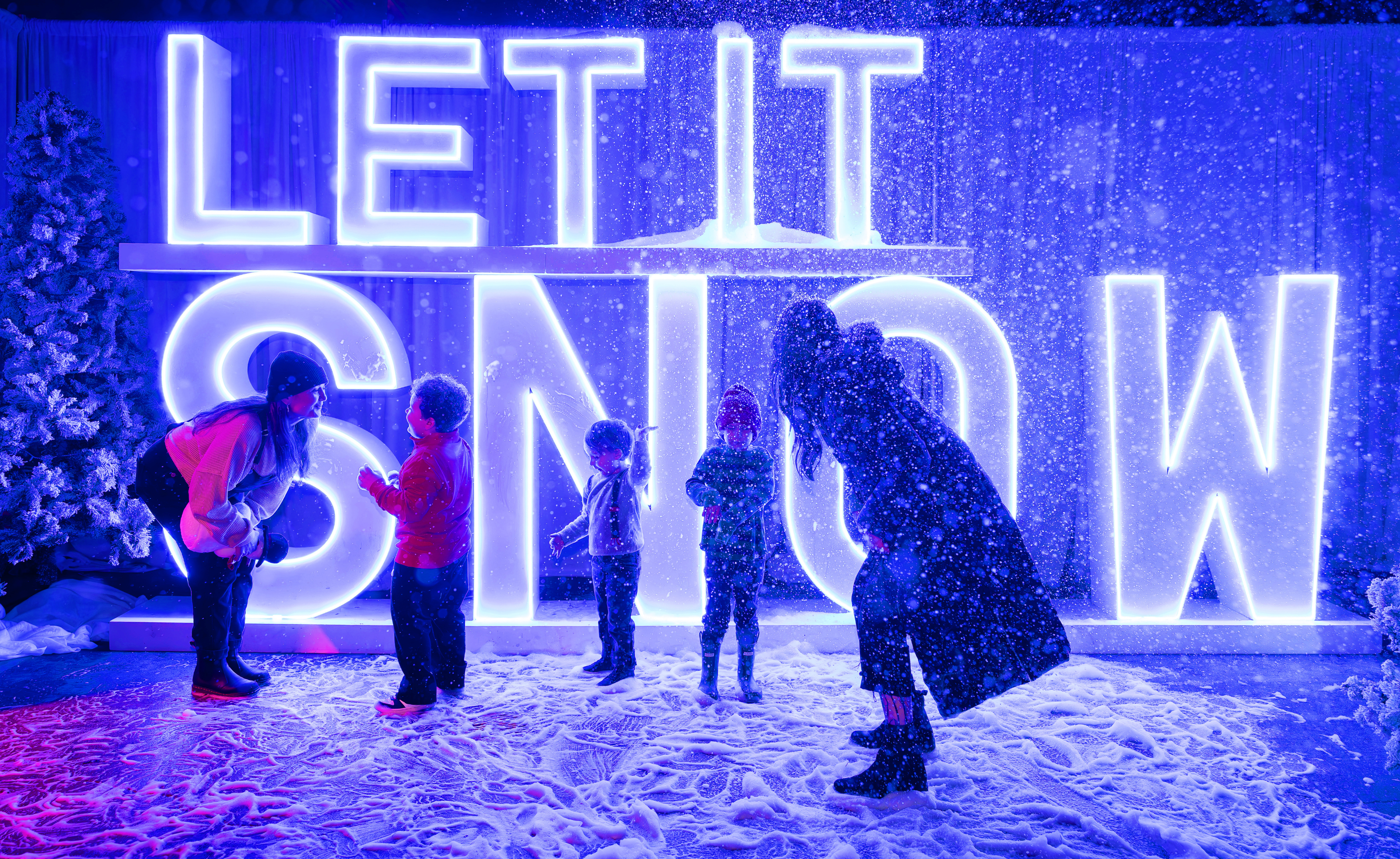 Family playing in the snow at Holiday Magic