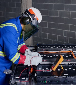 dismantling battery-factory-employee with helmet and jacket