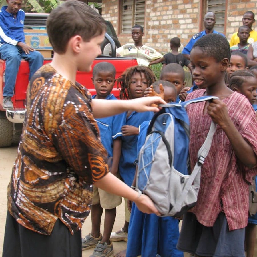 boy giving backpack
