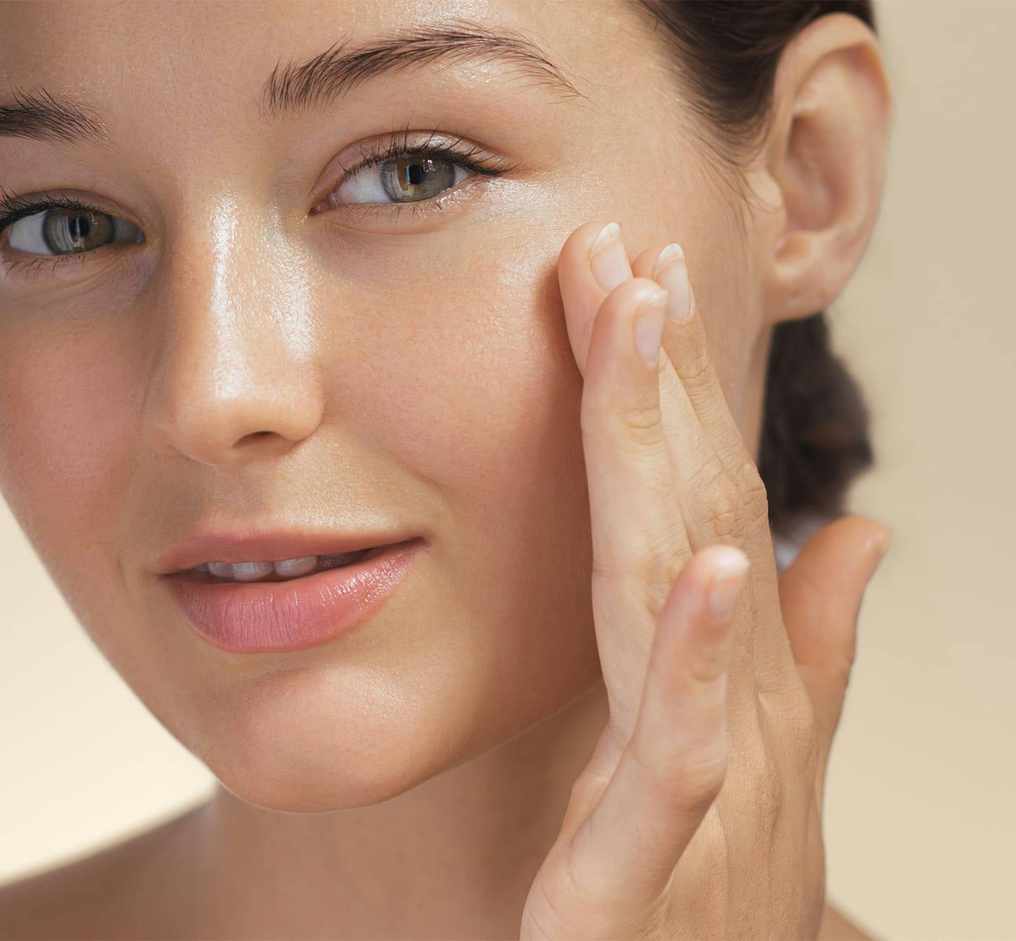 woman applying cream to face