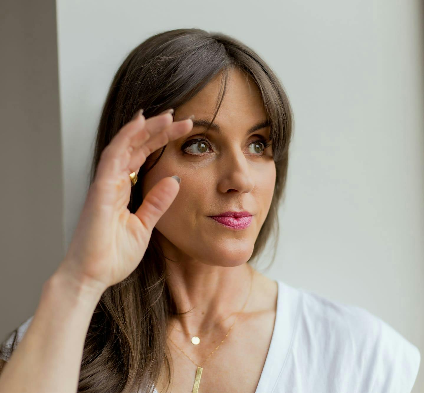 woman holding hand up to face