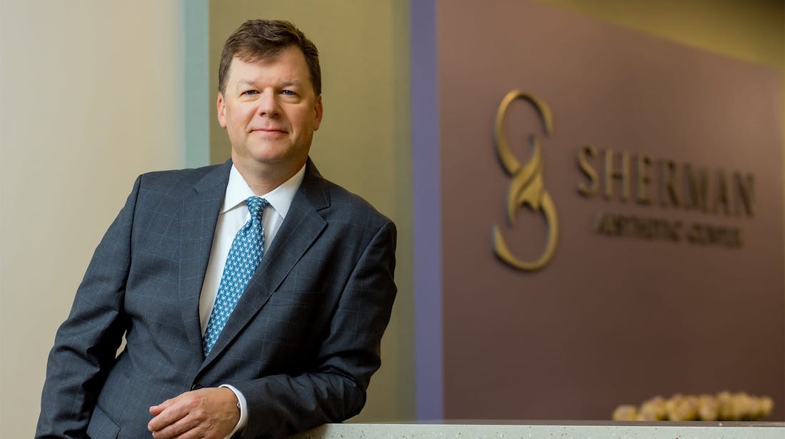 Dr Melson leaning on reception counter