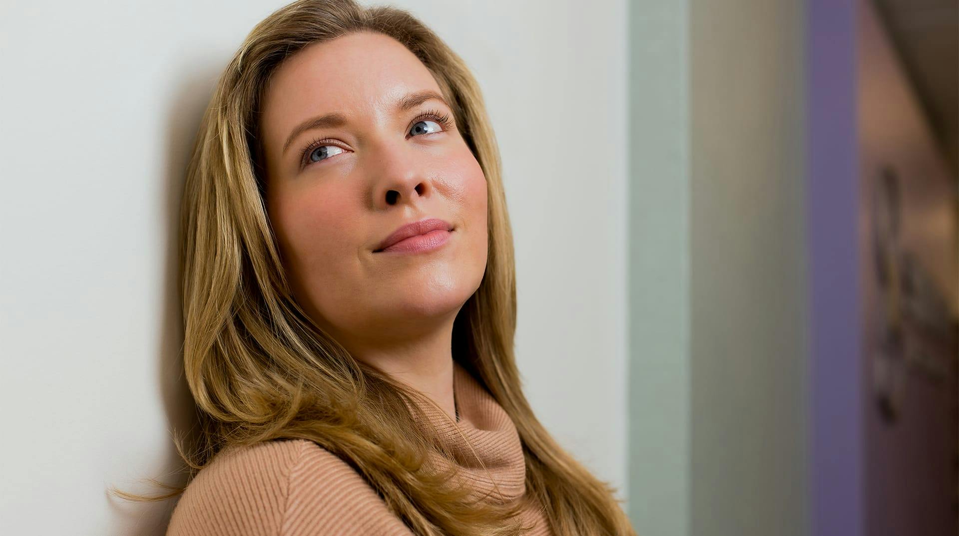 woman leaning on wall and looking to the side