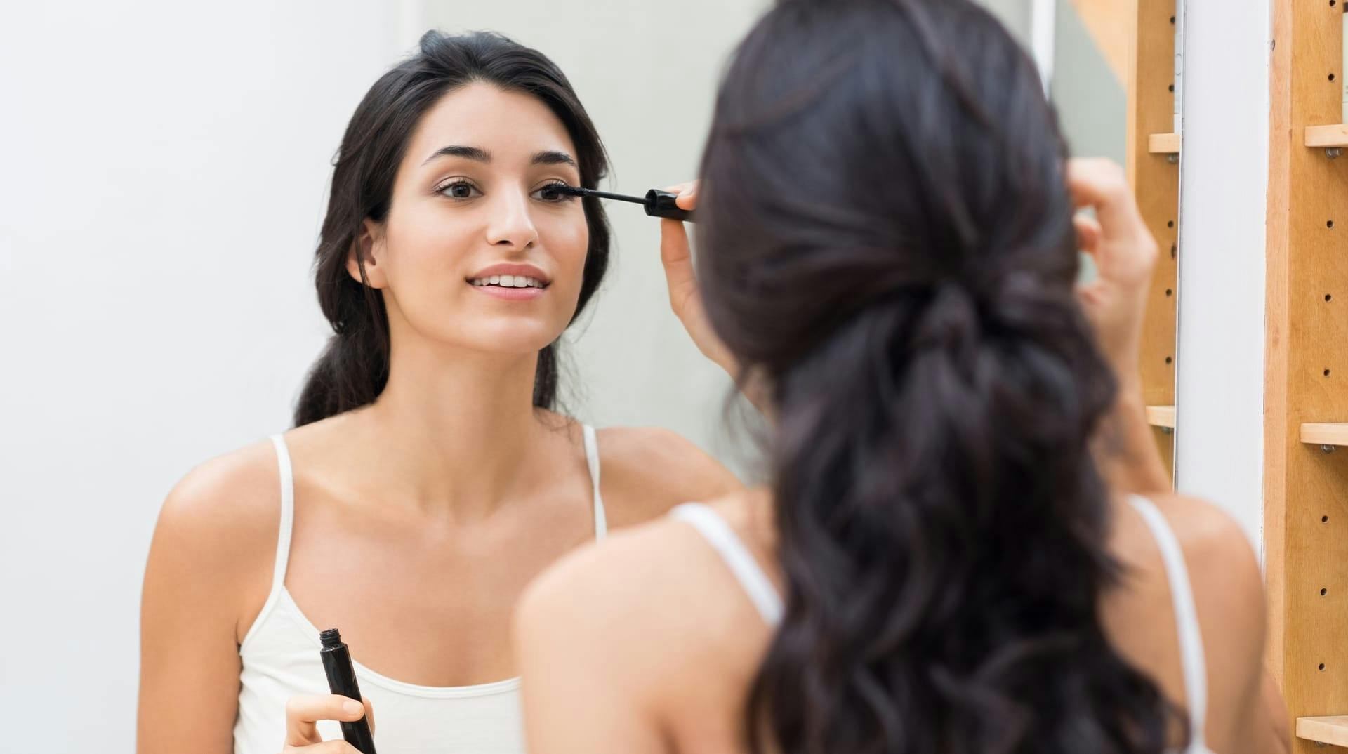 smiling woman applying eye product