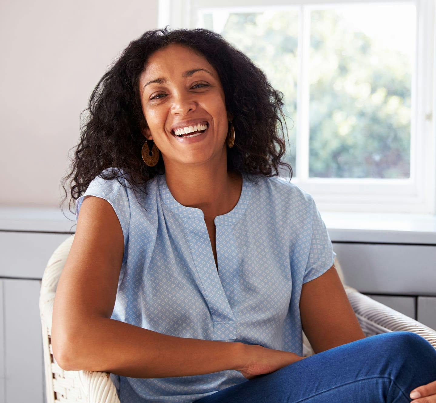 smiling woman in wicker chair