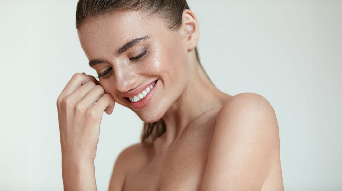 smiling woman with hand at her face