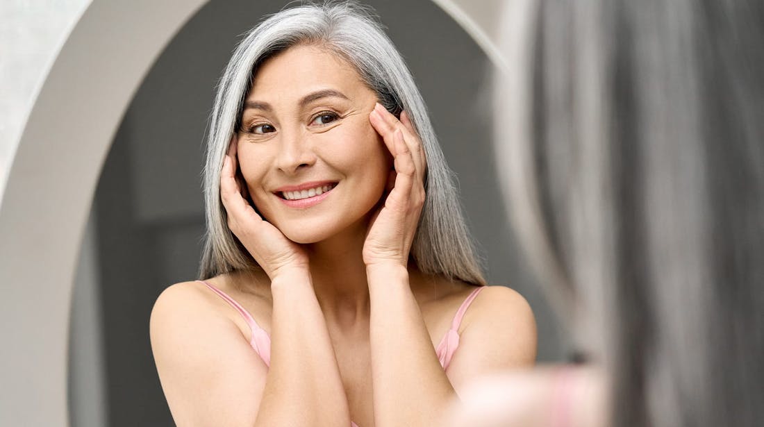 smiling woman pressing temples