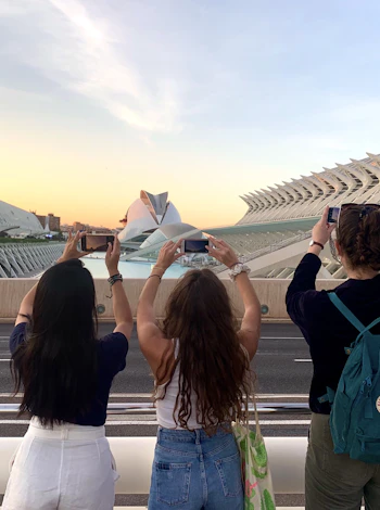 Étudiants photographiant la Cité des Arts pendant des cours de langue à Valence, au coucher du soleil.