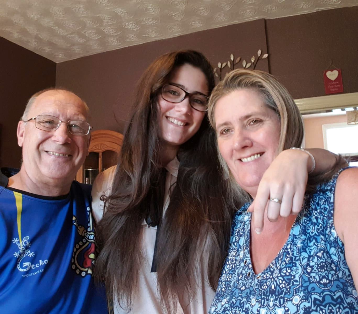 Austauschschülerin lächelt mit ihrer Gastfamilie und baut enge Bindungen auf, während sie das tägliche Leben während ihres Semesters in England genießt.