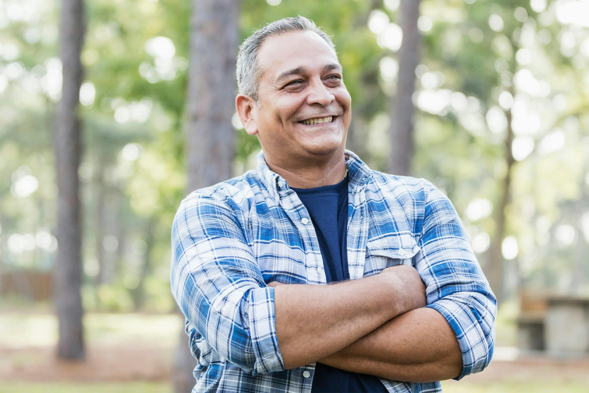 man crossing his arms in park