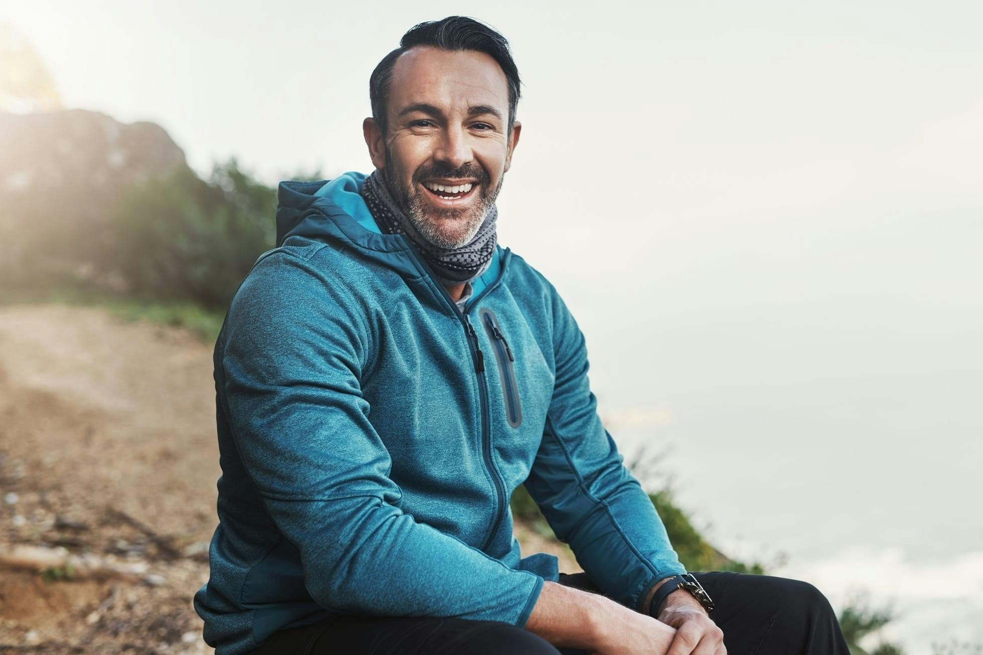 man sitting on beachside cliff