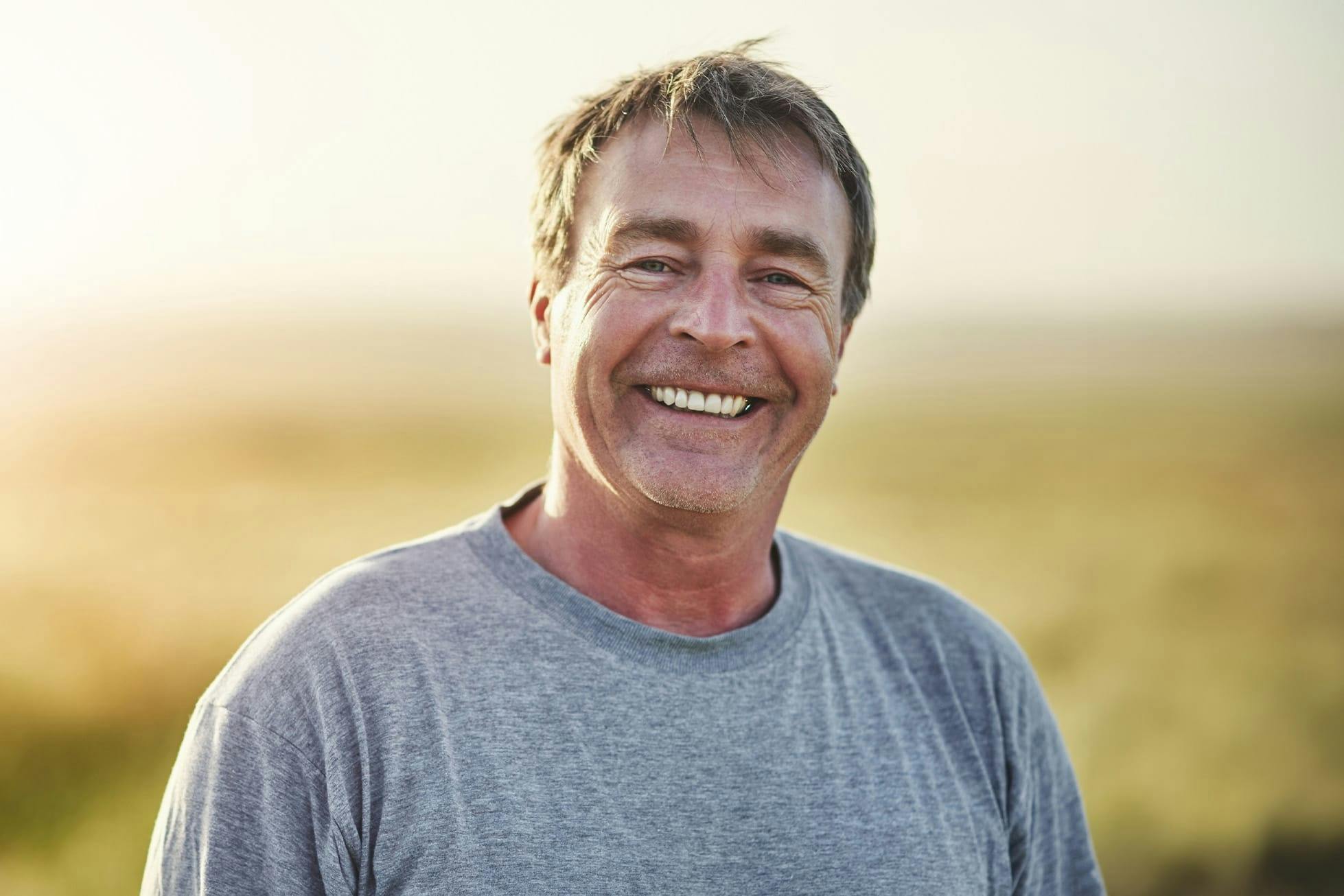 man smiling in grey t-shirt