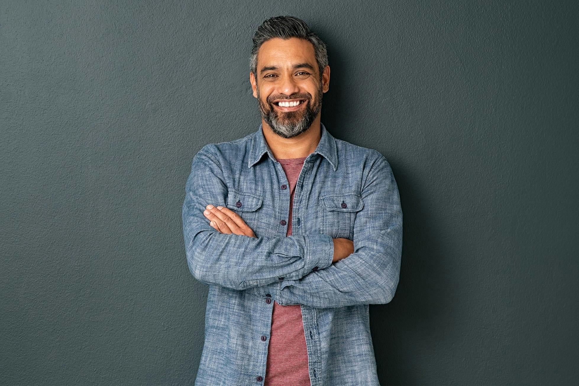 man smiling with his arms crossed