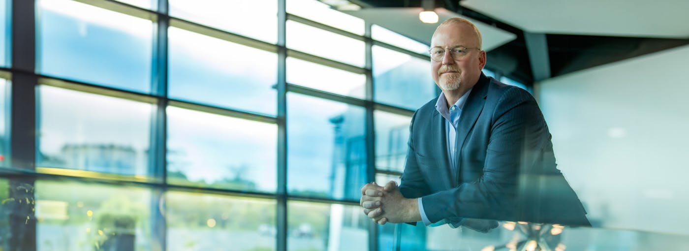 man leaning on glass table