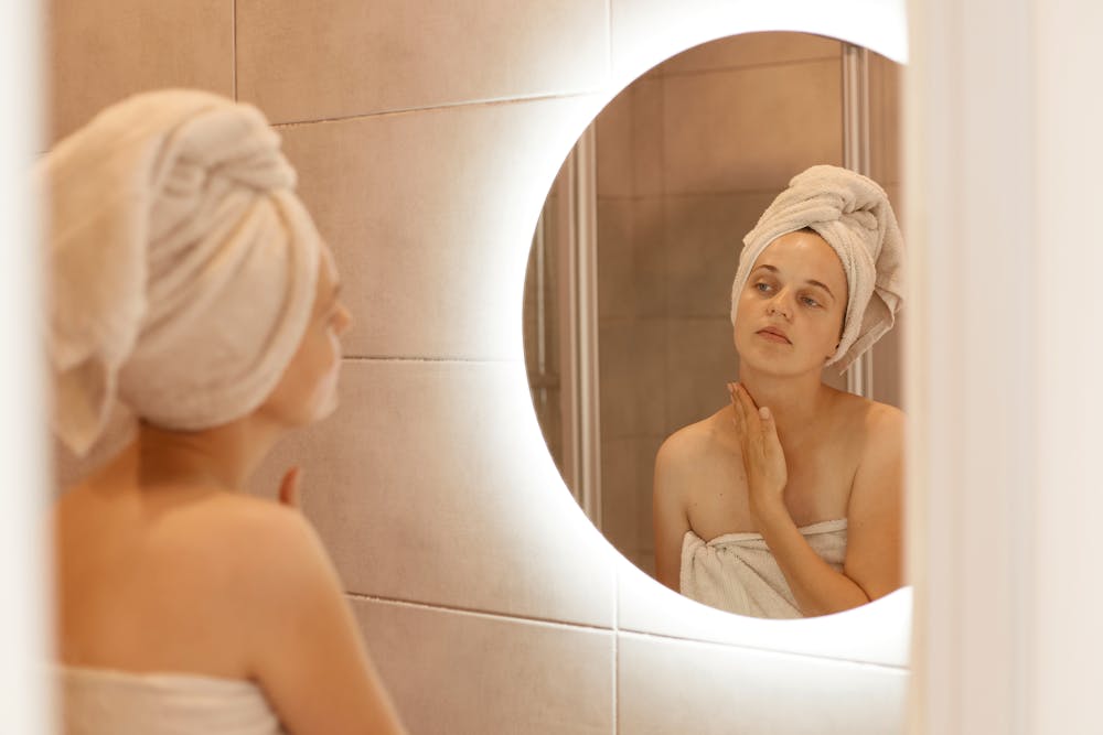 Woman in bathroom looking at mirror