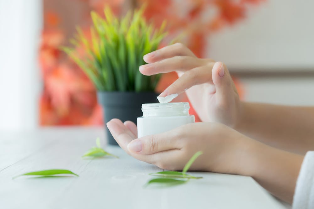 Woman with skin cream in hands
