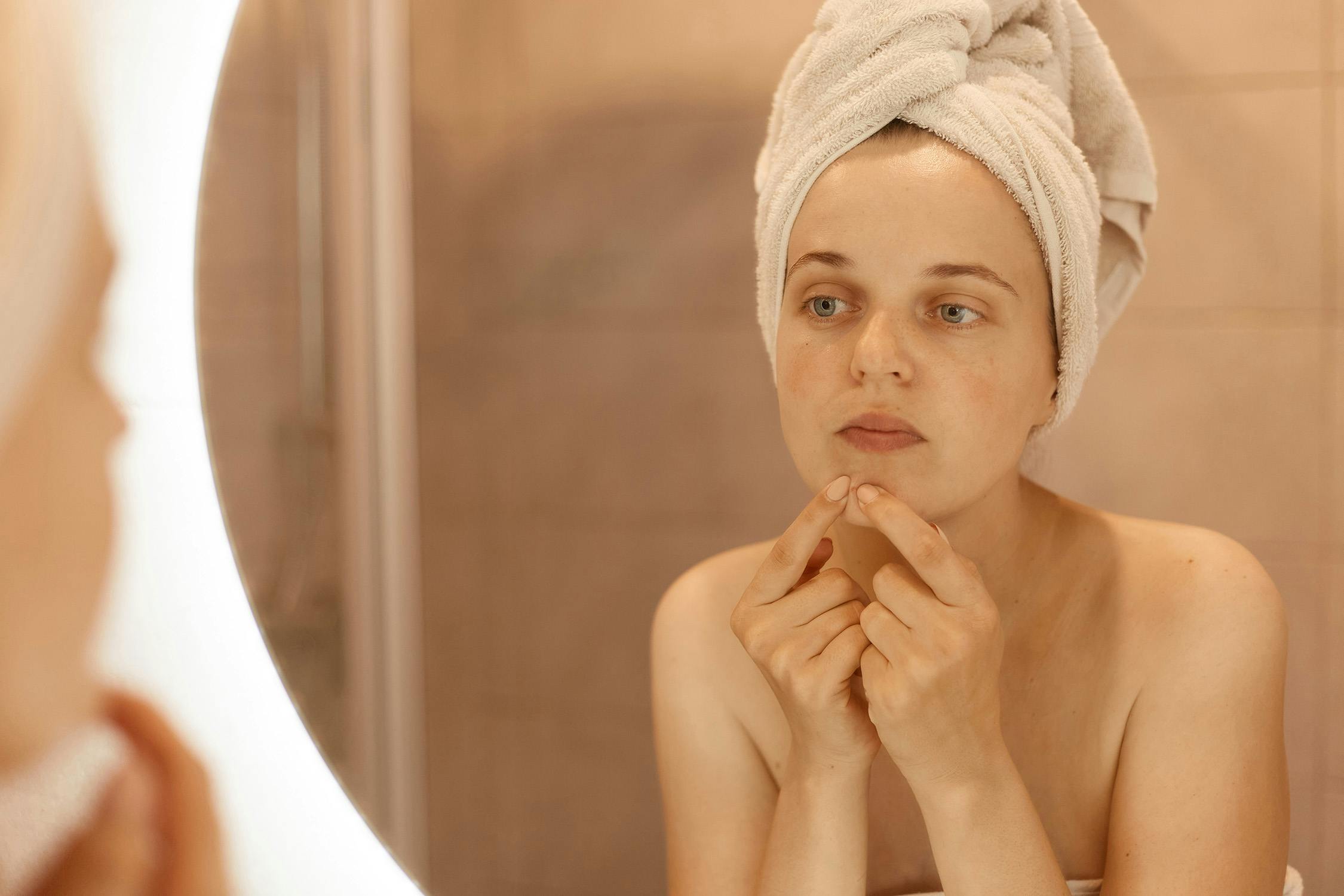 Woman trying to pop pimples