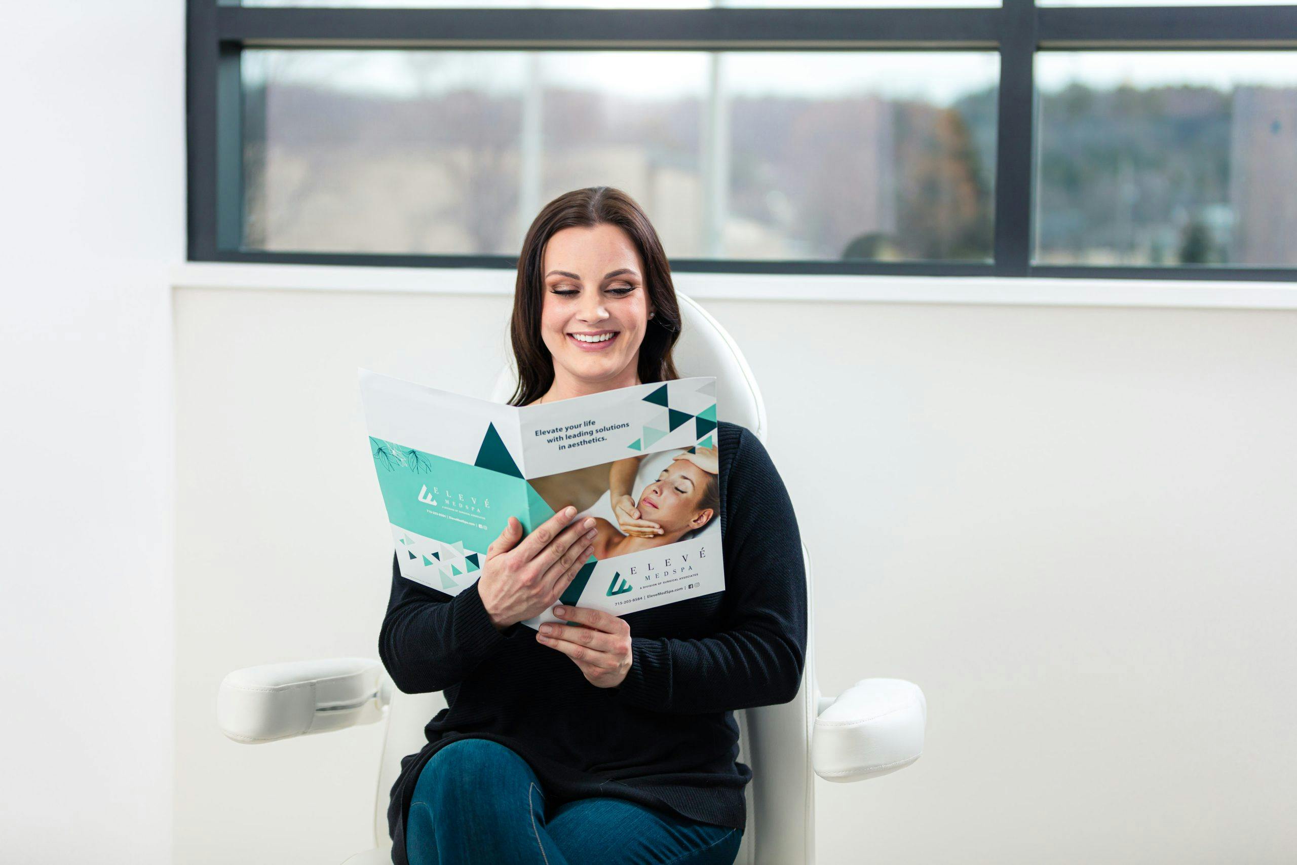 woman smiling and reading Eleve Brochure