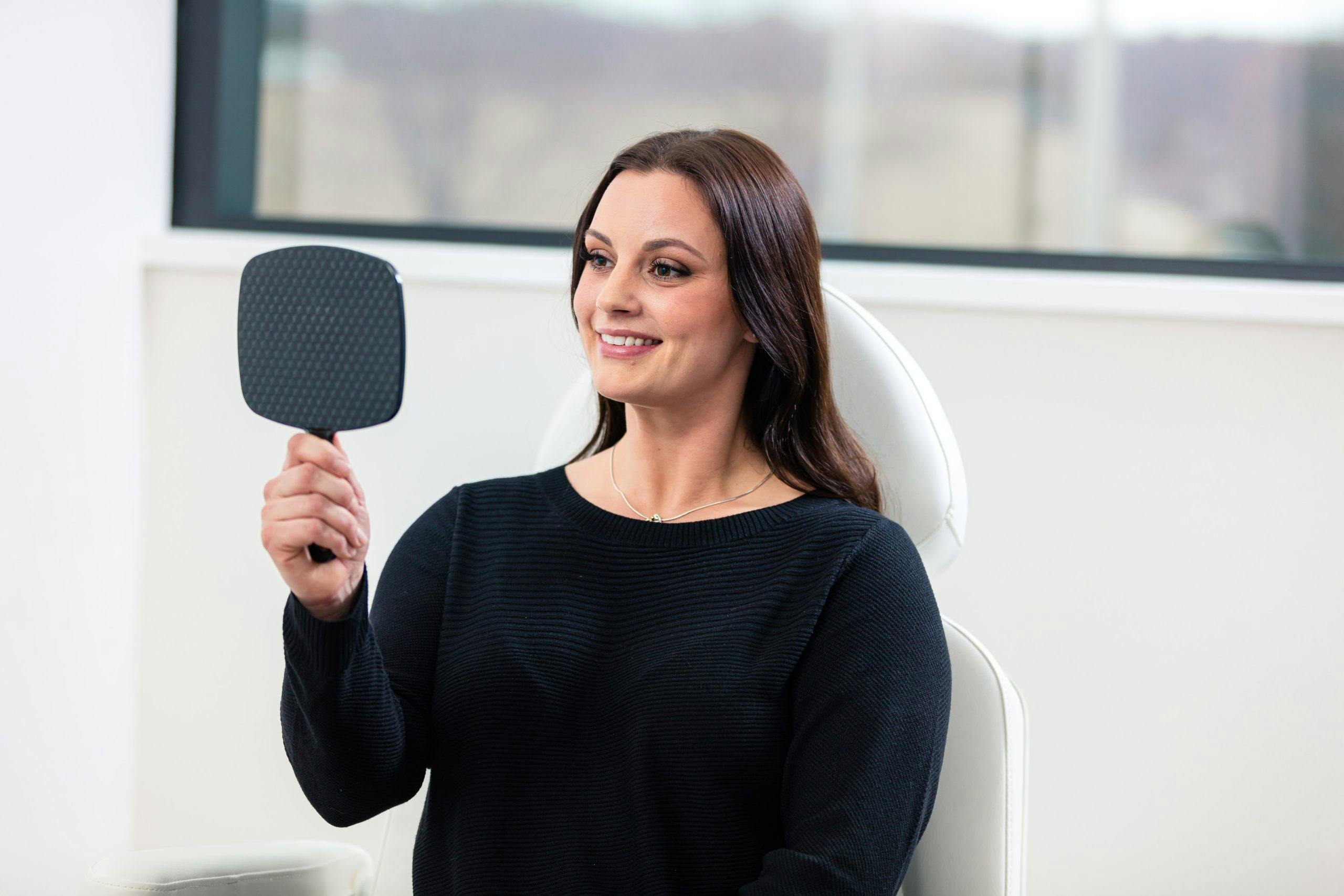 woman smiling and looking at mirror