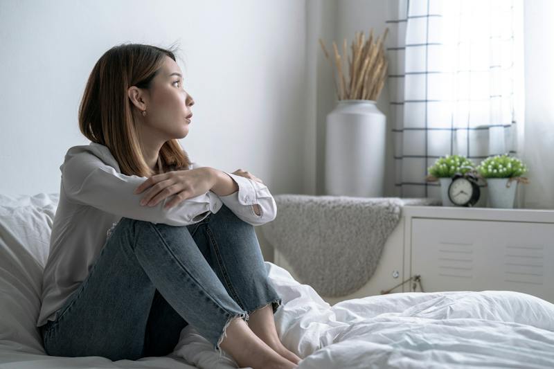 woman sitting on her bed