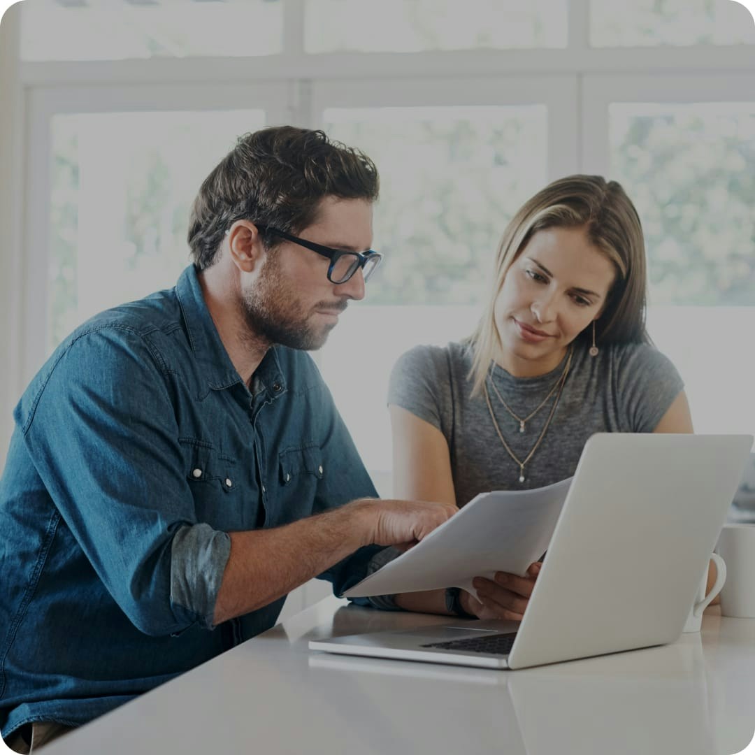 a man and woman looking at a paper