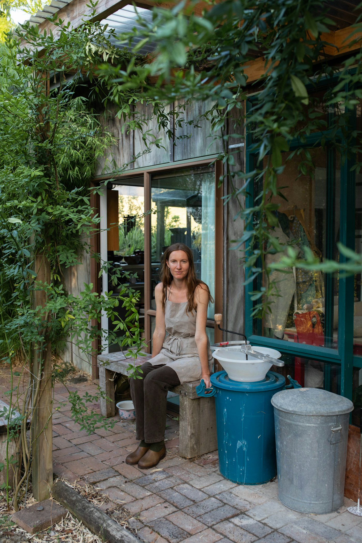 Jaime Jenkins sitting in the doorway of her Tauranga Moana studio.