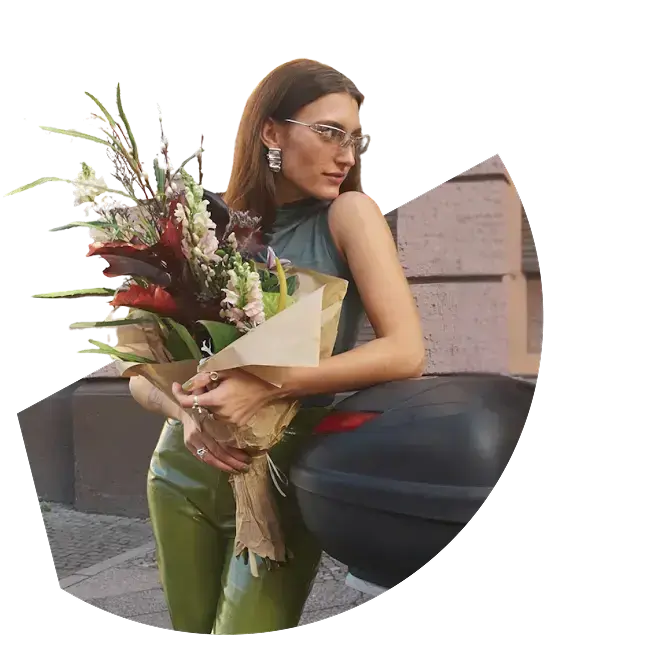 Woman with flowers, on holiday, happy with Eu roaming that is included in her mobile network data plan