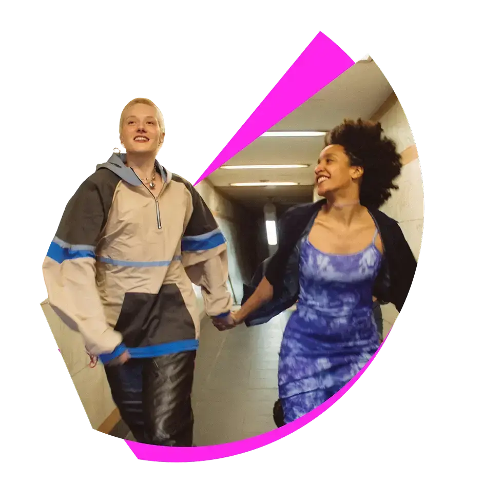 Two female friends holding hands, looking happy after discovering Slice mobile