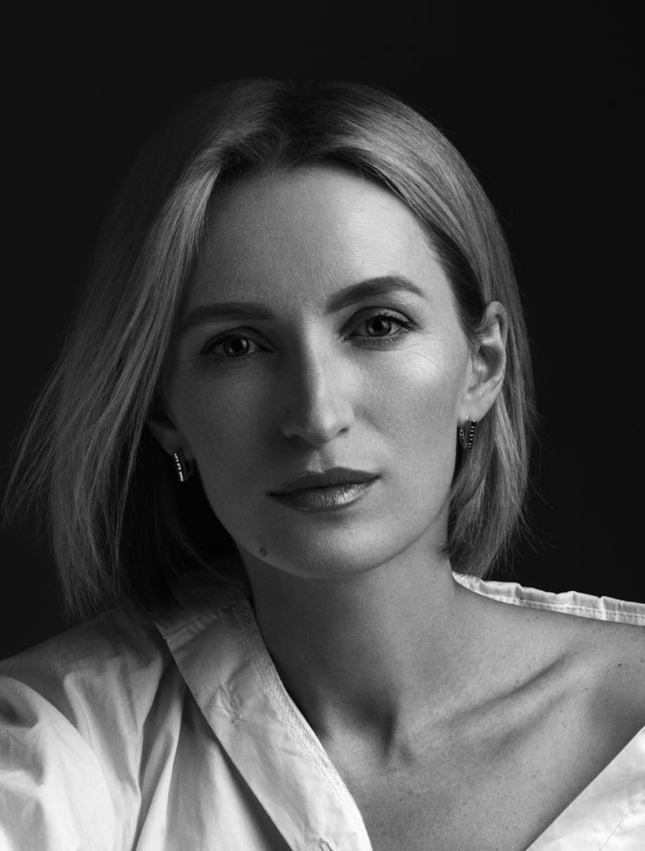 Woman looking forward, her shirt pulled back off one shoulder