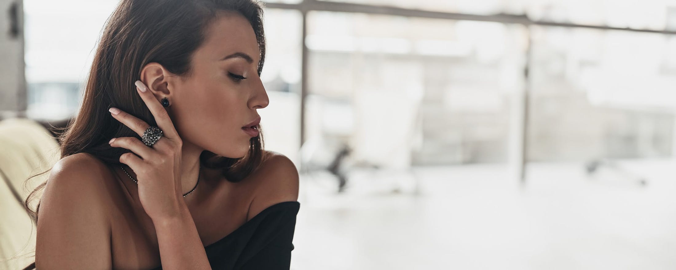 woman pushing her hair behind her shoulder