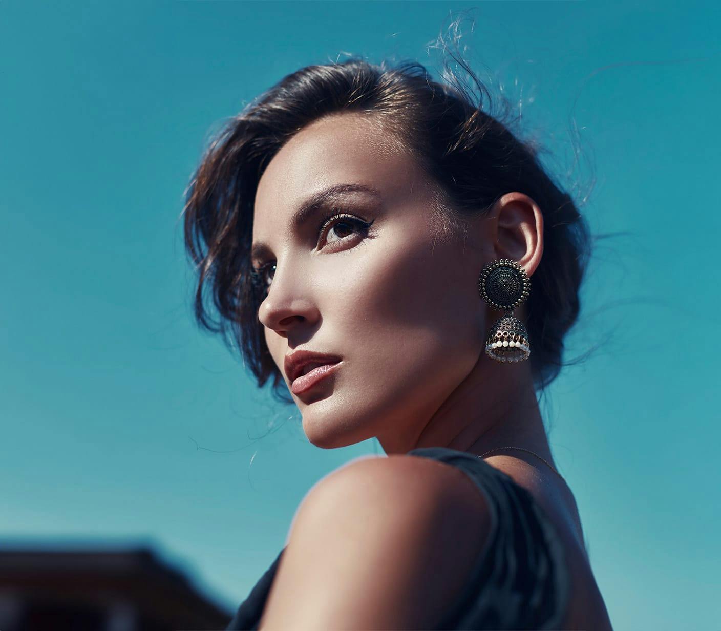 woman with large earrings standing outside