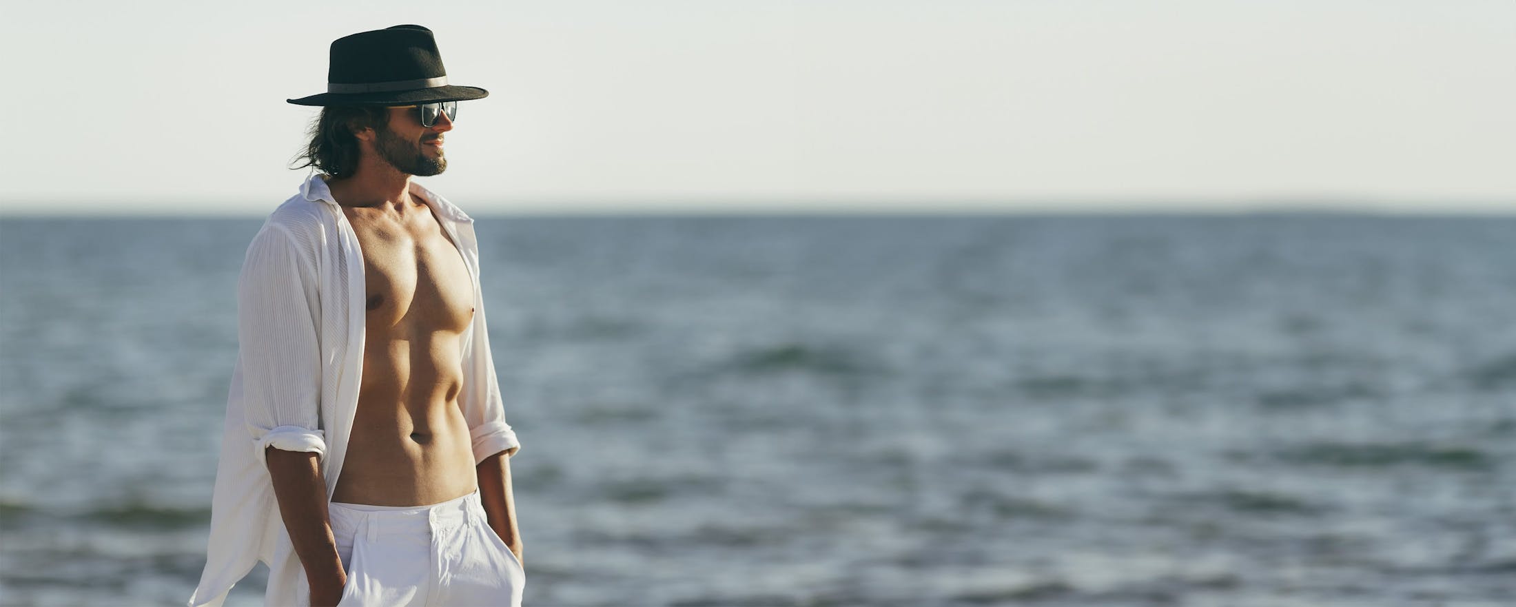 Man on the beach with his shirt open