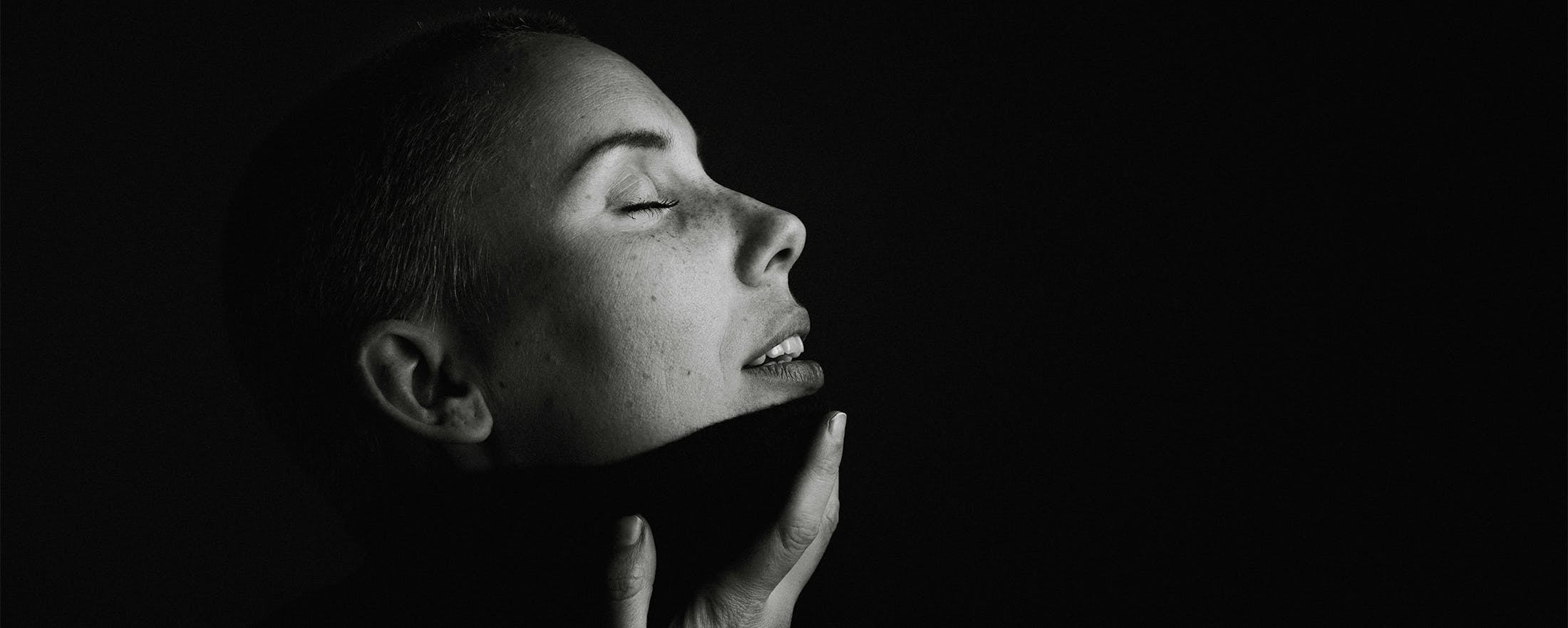 woman touching chin with eyes closed