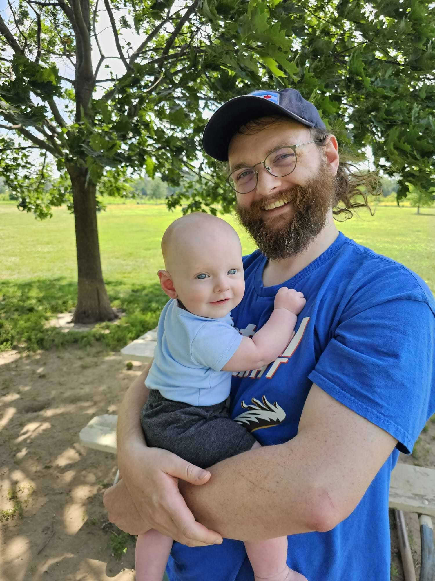Walter Ferrell and Baby Declan resting in the shade of a tree on a hot summer day.
