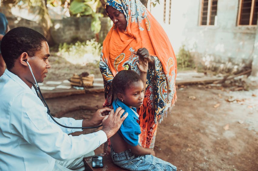 nurse using stethoscope on child's back