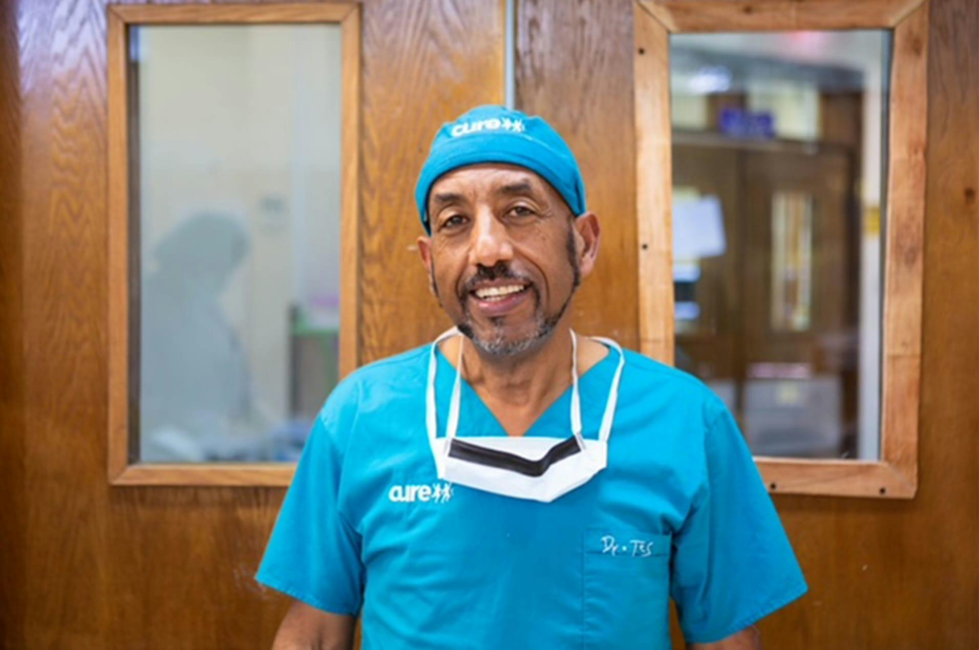 dr tesfate mulat smiling in medical attire