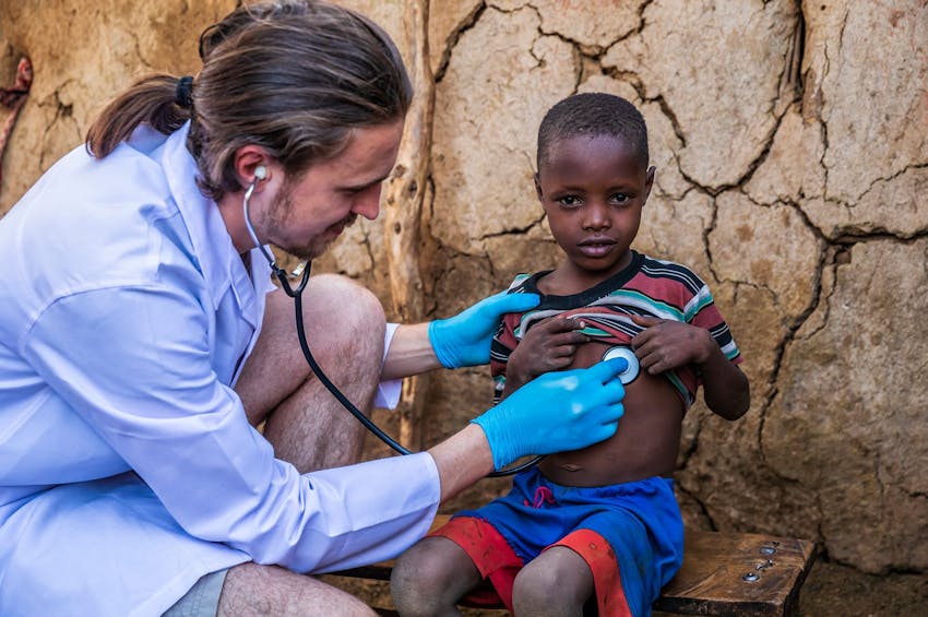 doctor holding stethoscope to child's chest