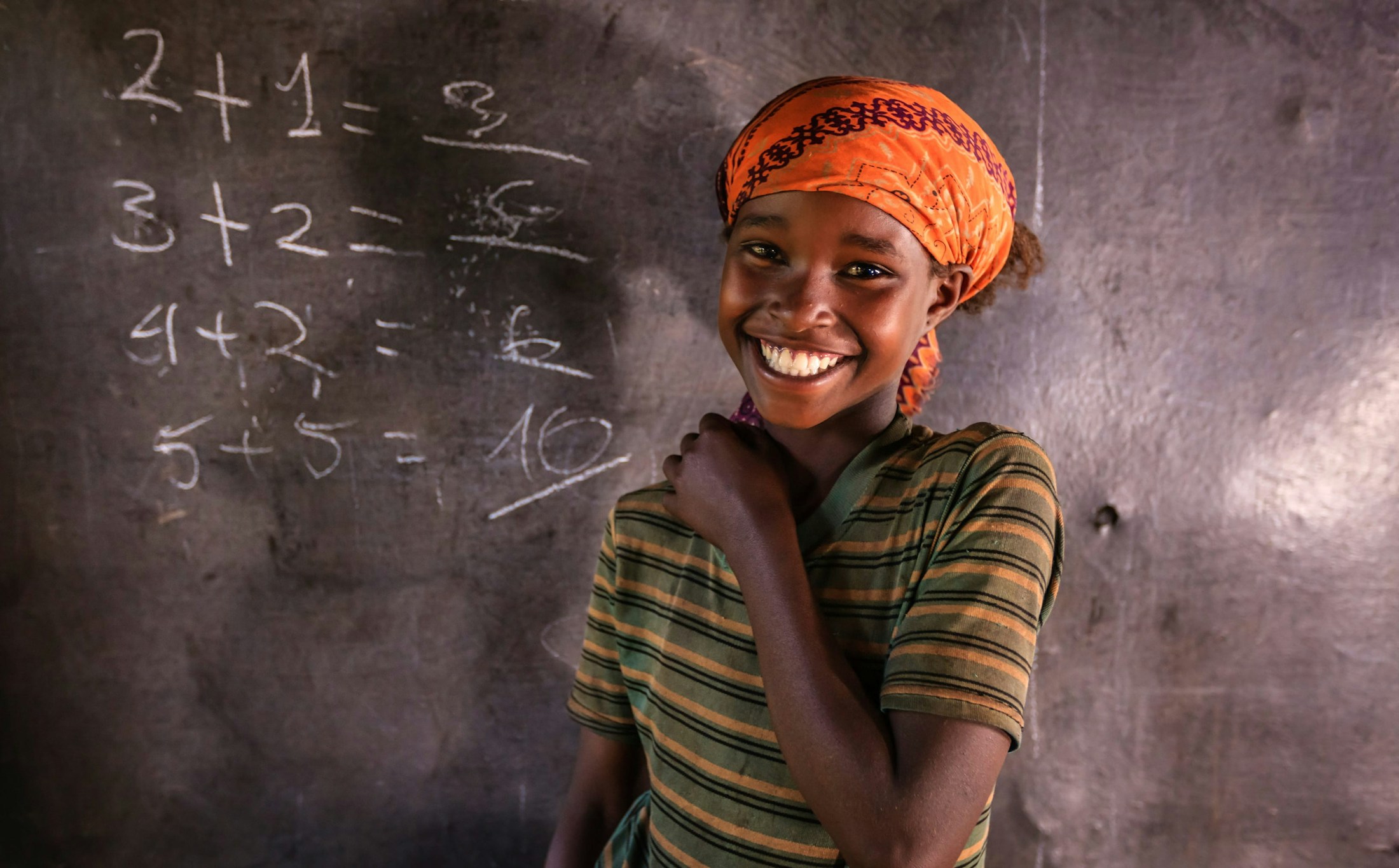 girl smiling standing infront of chalkboard