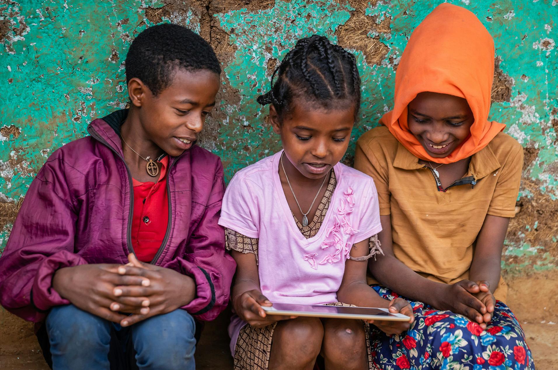 3 kids looking at tablet