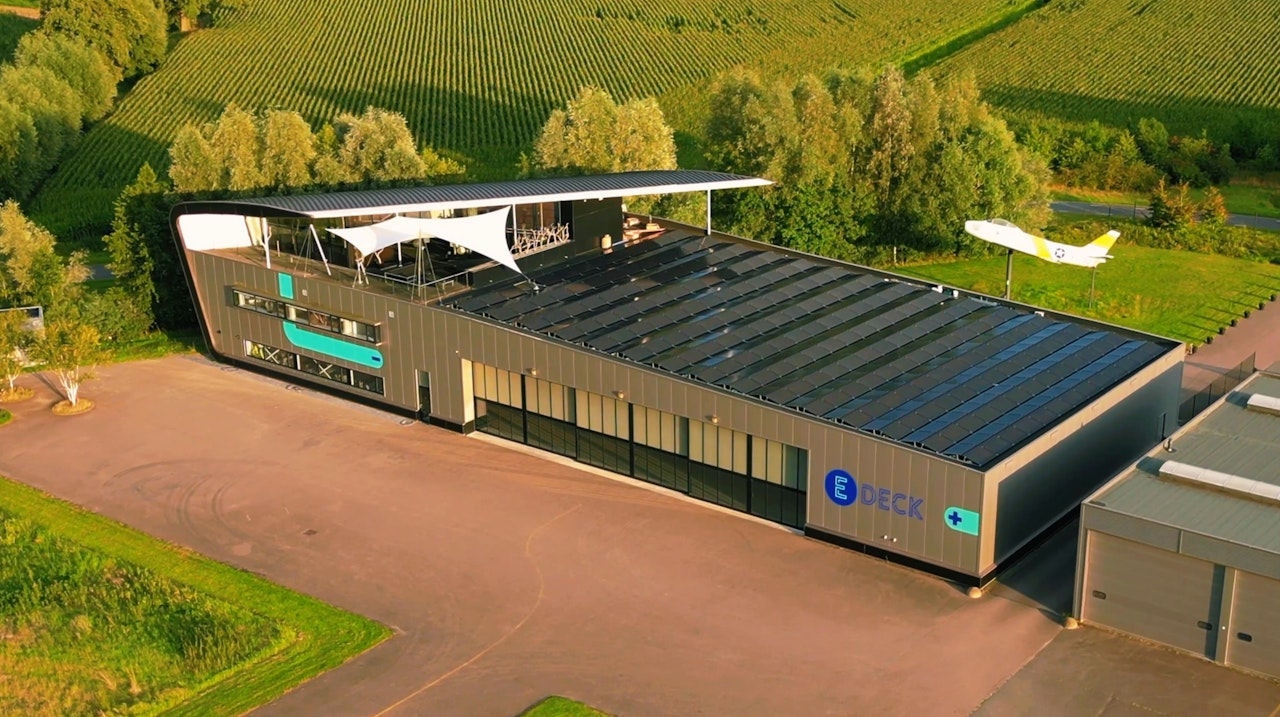 Luchtfoto van de E-Deck hangaar met dak vol zonnepanelen