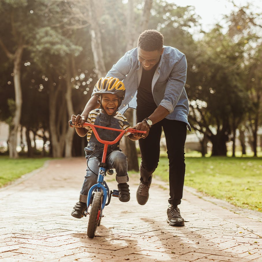 Dad helping his son ride a bike after hyperbaric oxygen therapy in Jacksonville, FL