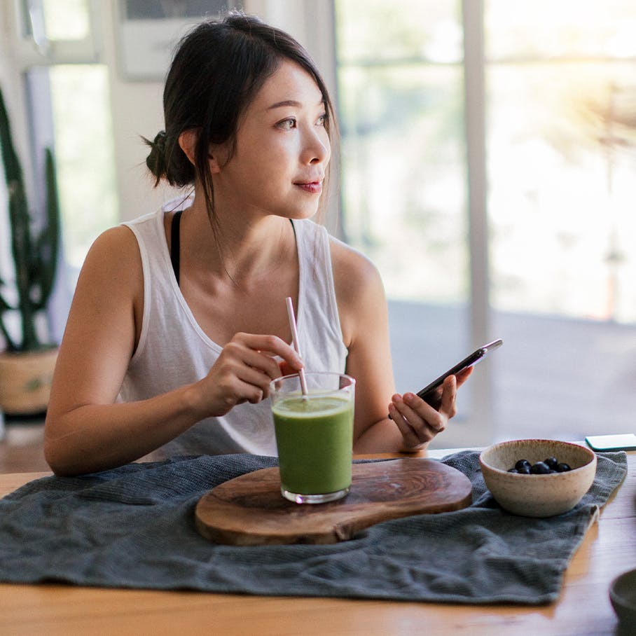 Woman sitting down with a green drink
