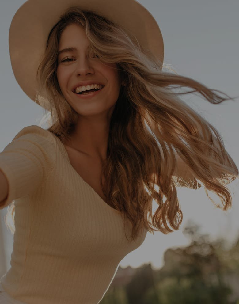 woman with hat smiling after visiting the med spa in Orlando, FL