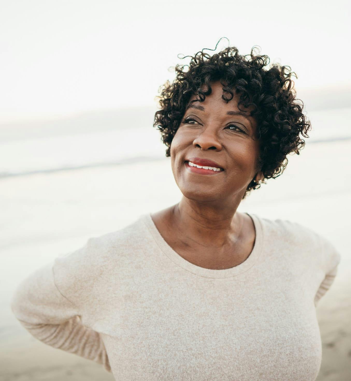 Woman with curly hair standing outside