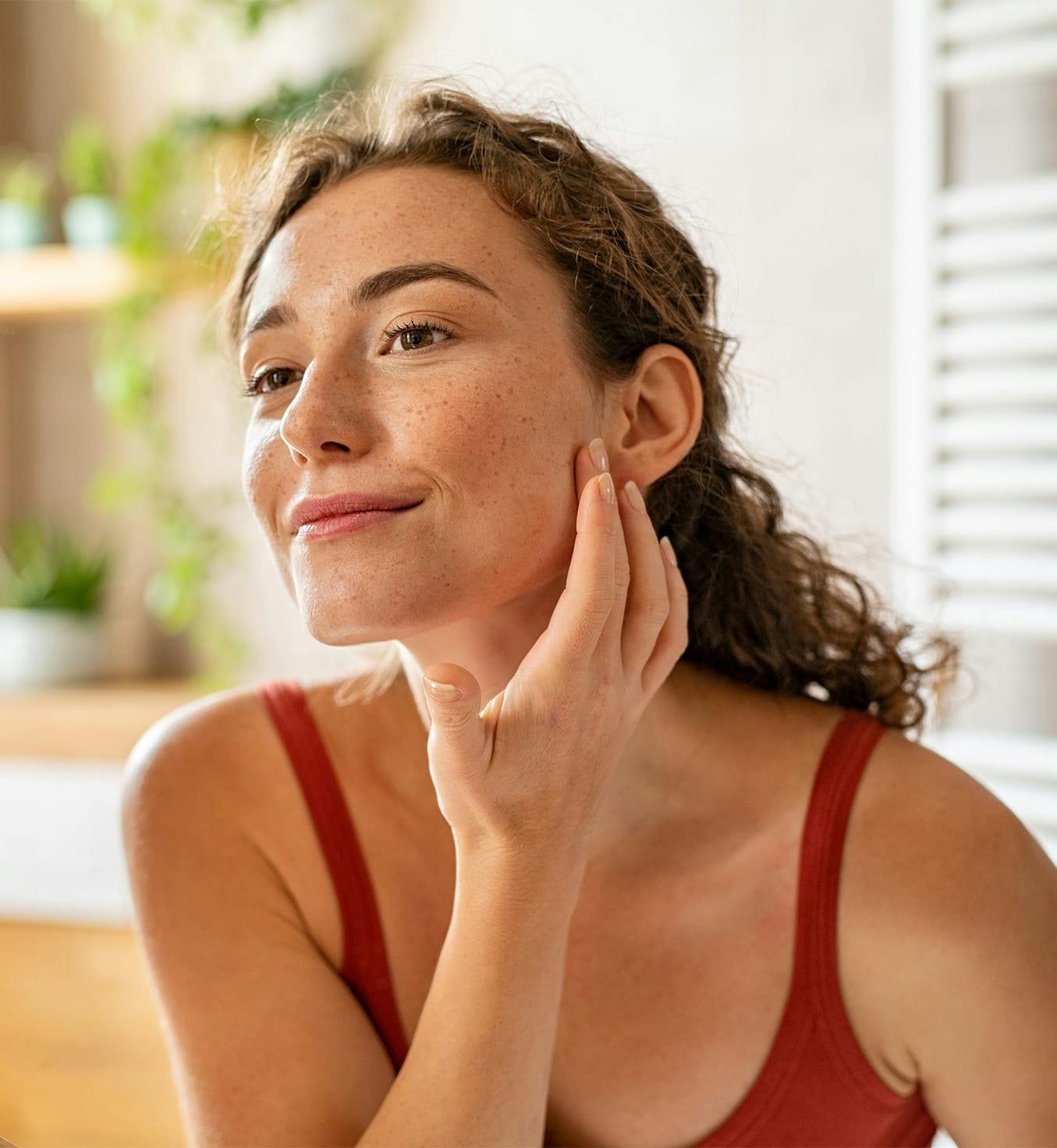 woman touching her face after microneedling in Springfield, MO