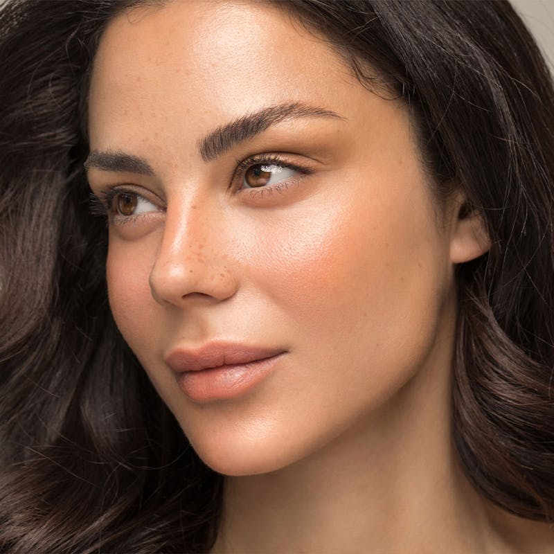 Woman with glowing skin after receiving aesthetic treatment at Serotonin Centers.