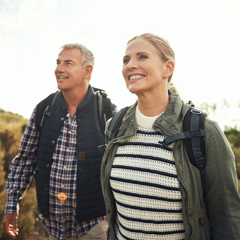 Happy couple hiking after receiving hormone therapy at Serotonin Centers.