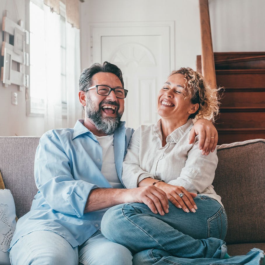 happy woman with partner on the couch after Emsella treatment in Stamford, CT